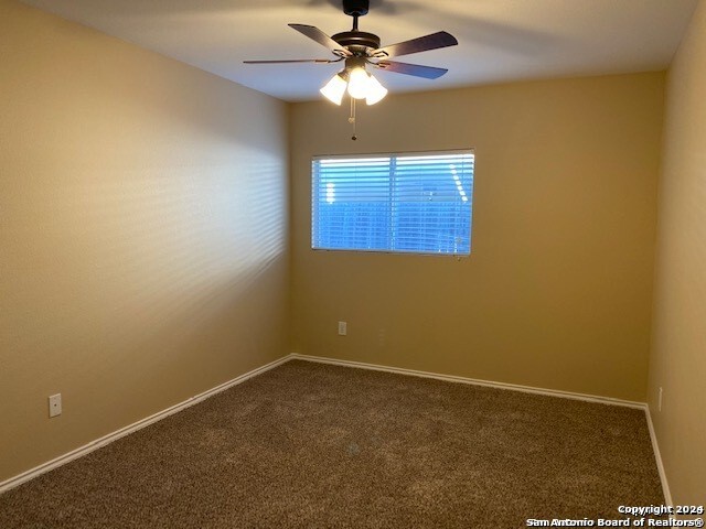 carpeted empty room featuring ceiling fan