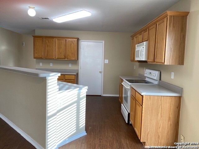 kitchen featuring white appliances and dark wood-type flooring