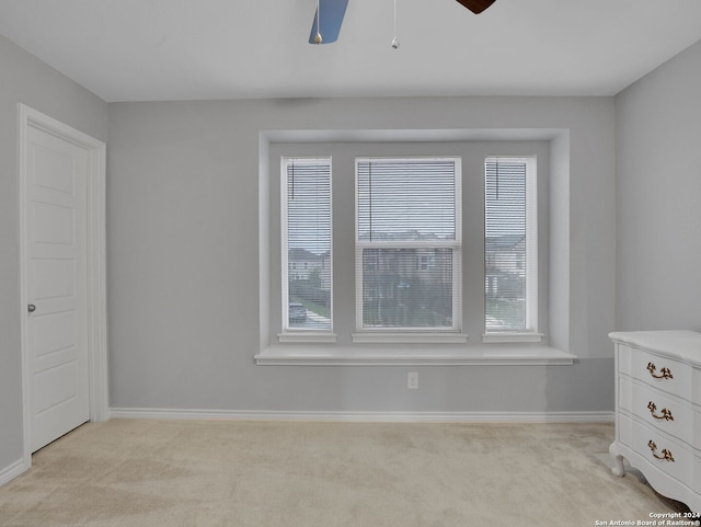 carpeted spare room with ceiling fan