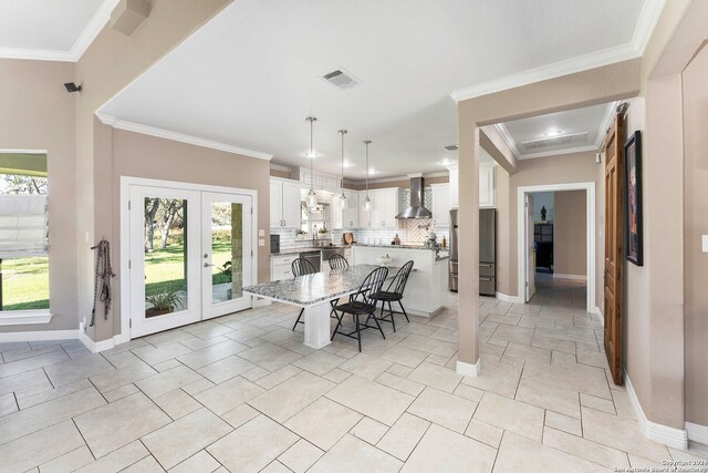 dining space with french doors and ornamental molding