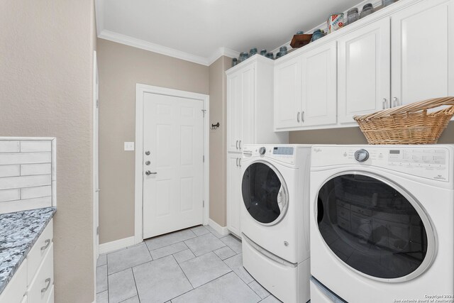 washroom with light tile patterned flooring, cabinets, ornamental molding, and washing machine and dryer