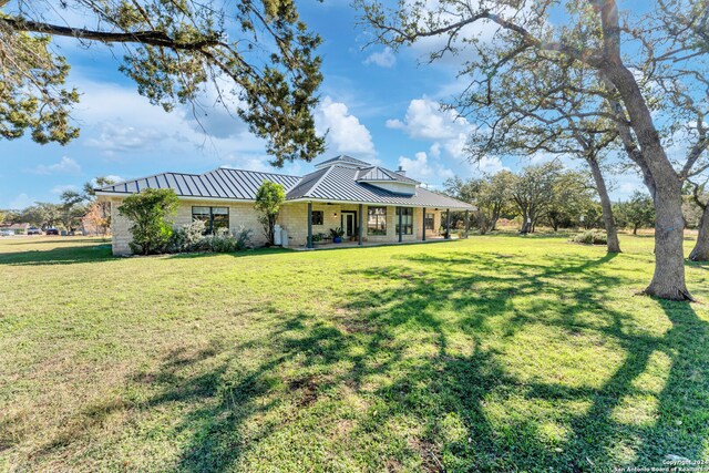 back of property with covered porch and a yard