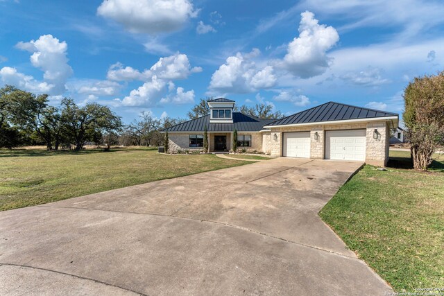 view of front of property featuring a front yard and a garage