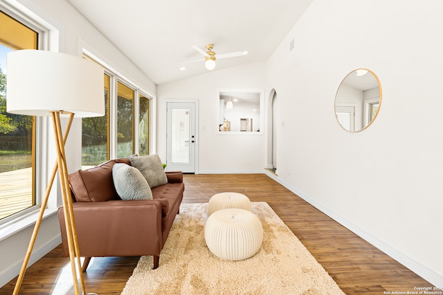 living room with ceiling fan, hardwood / wood-style floors, and vaulted ceiling