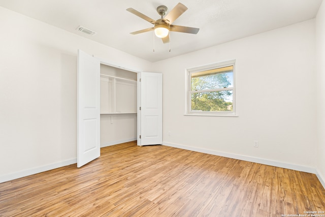 unfurnished bedroom with a closet, light hardwood / wood-style floors, and ceiling fan