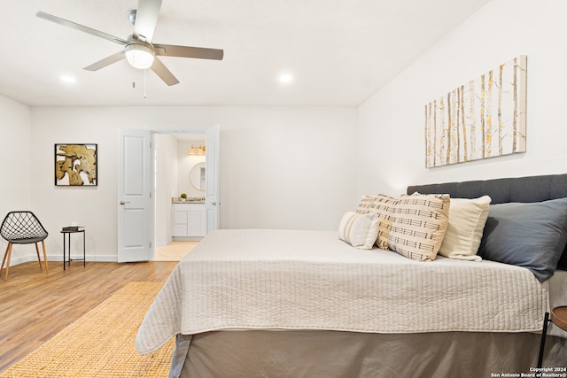 bedroom with hardwood / wood-style floors, ceiling fan, and connected bathroom