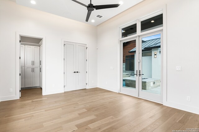 empty room featuring ceiling fan, french doors, and light wood-type flooring