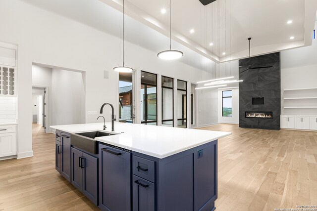 kitchen featuring sink, pendant lighting, a center island with sink, and light hardwood / wood-style floors