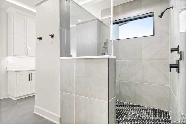 bathroom featuring tile patterned floors, vanity, and tiled shower