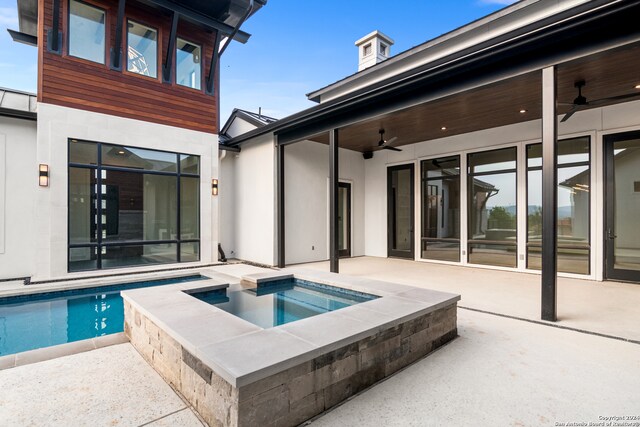 view of swimming pool with ceiling fan, an in ground hot tub, and a patio