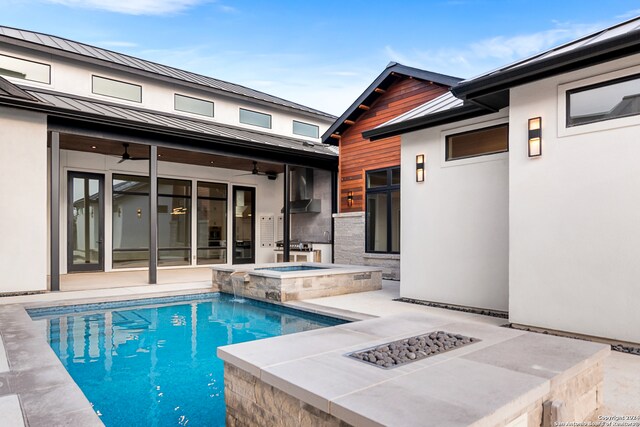 view of pool featuring an in ground hot tub, a fire pit, ceiling fan, and a patio area