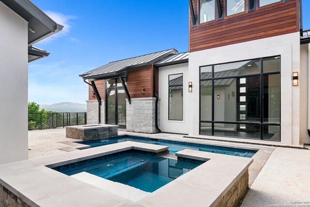 view of pool with a mountain view and an in ground hot tub