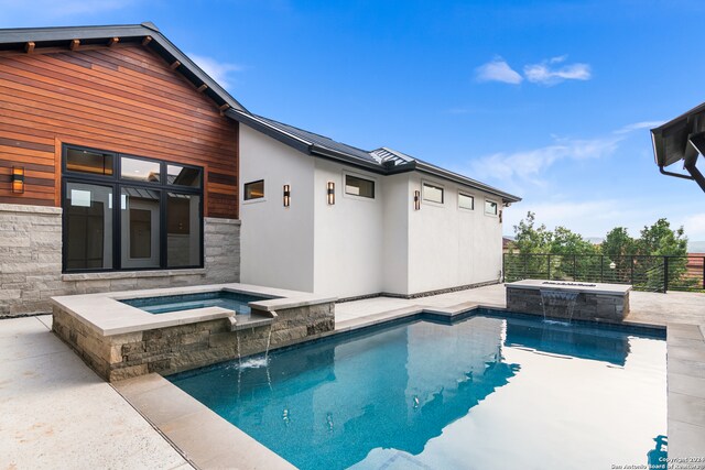 view of pool with an in ground hot tub and pool water feature