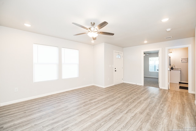 unfurnished living room featuring light wood-type flooring and ceiling fan