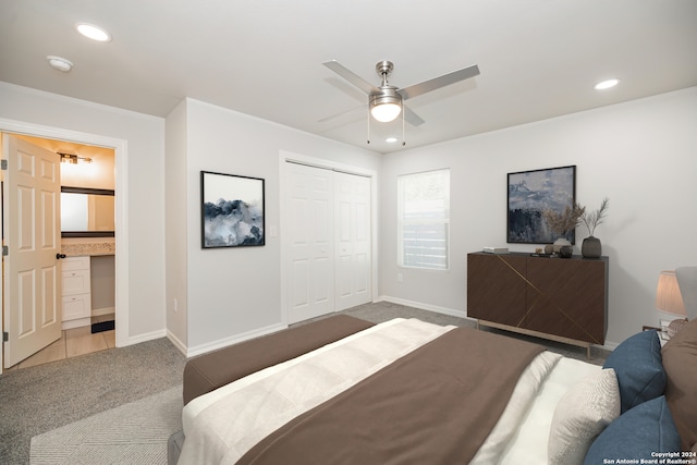 carpeted bedroom featuring a closet, ceiling fan, and ensuite bathroom