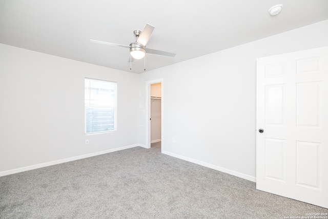 empty room featuring ceiling fan and light colored carpet