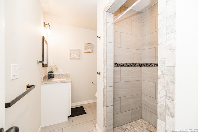 bathroom with vanity, toilet, and tiled shower