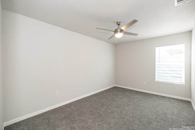 empty room with dark carpet and ceiling fan