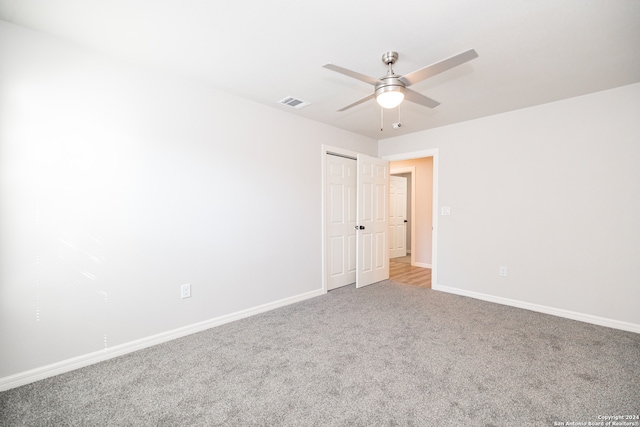 empty room with light colored carpet and ceiling fan