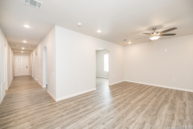 empty room with ceiling fan and light wood-type flooring