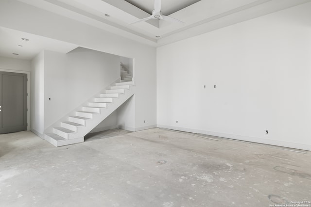 interior space featuring unfinished concrete floors, ceiling fan, baseboards, and stairs