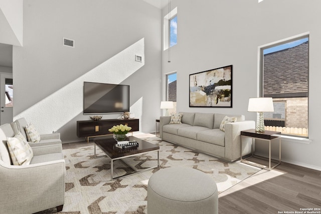 living room featuring hardwood / wood-style floors, a wealth of natural light, and a high ceiling