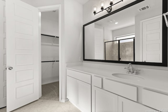 bathroom with tile patterned flooring, vanity, and a shower with shower door