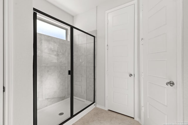 bathroom featuring tile patterned flooring and an enclosed shower