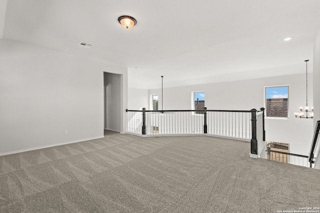 spare room with carpet floors and a chandelier