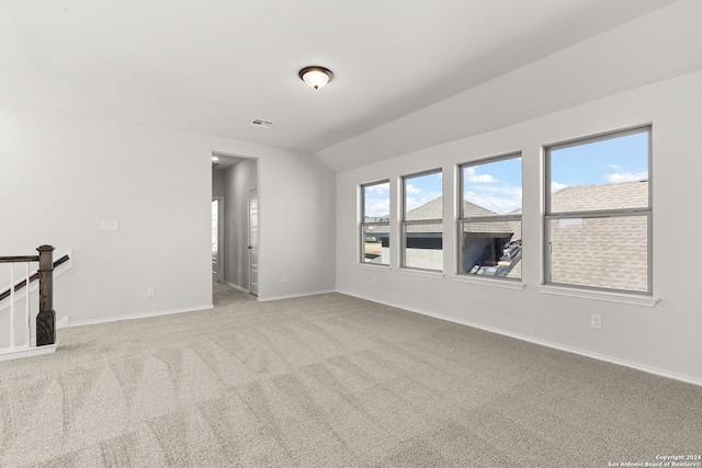 unfurnished living room with light colored carpet and lofted ceiling