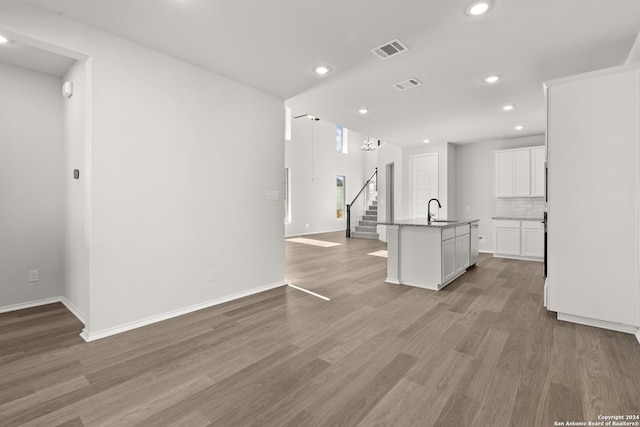 unfurnished living room with wood-type flooring and sink