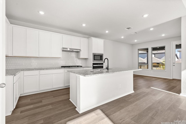 kitchen featuring dark hardwood / wood-style flooring, a center island with sink, and white cabinets