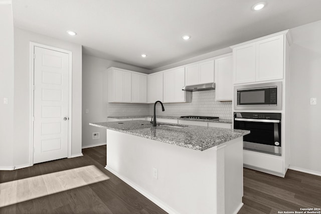 kitchen featuring white cabinets, oven, sink, range hood, and black microwave