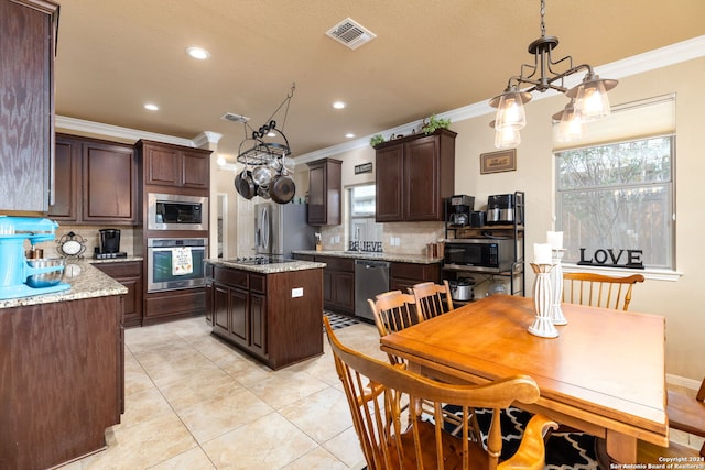 kitchen with a center island, hanging light fixtures, tasteful backsplash, dark brown cabinets, and stainless steel appliances