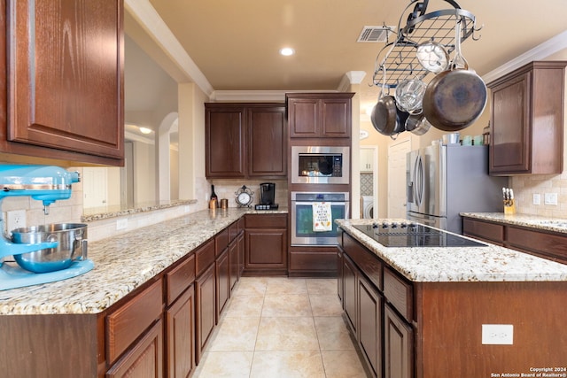 kitchen with kitchen peninsula, backsplash, stainless steel appliances, crown molding, and light tile patterned floors