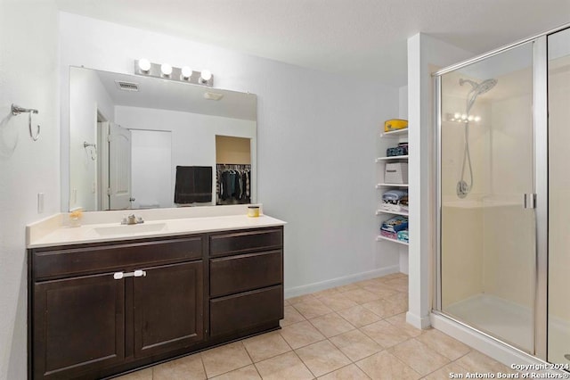 bathroom with walk in shower, tile patterned floors, and vanity