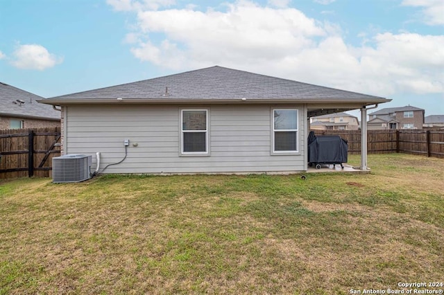 back of property with a yard and central air condition unit