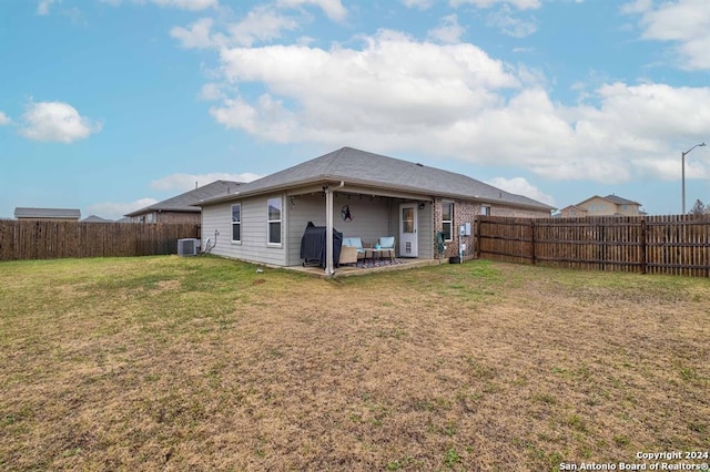 rear view of property with central AC unit, a lawn, and a patio area