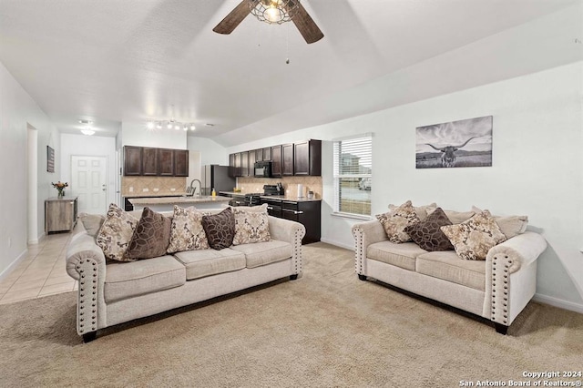 living room featuring lofted ceiling, sink, and light carpet