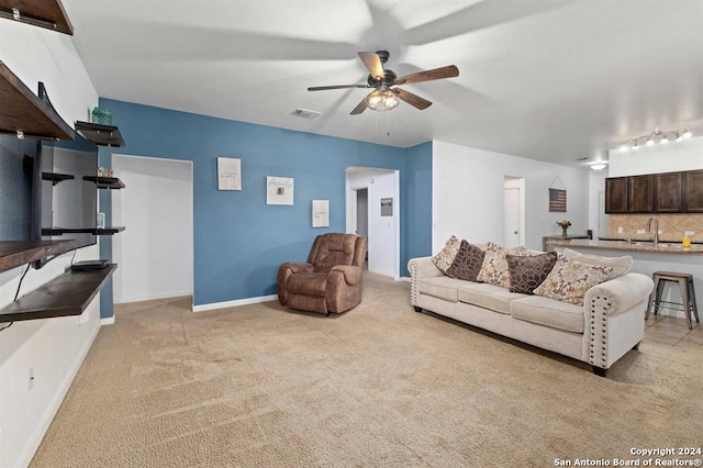 living room featuring ceiling fan, sink, and light carpet