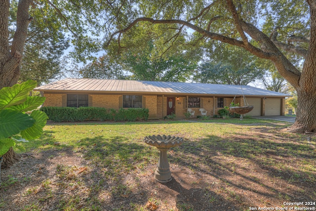 single story home with a garage and a front lawn