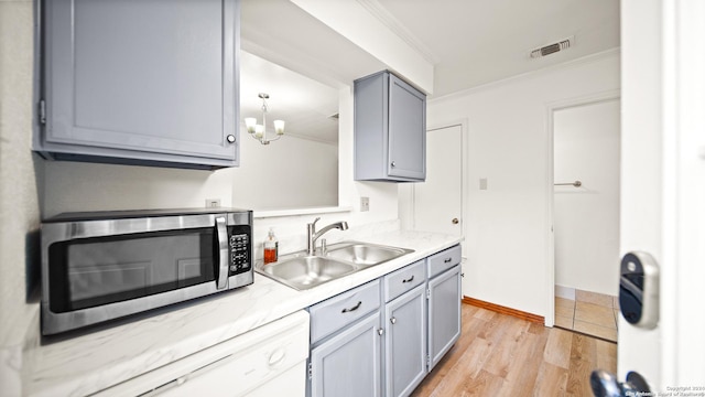 kitchen with crown molding, sink, light hardwood / wood-style floors, and an inviting chandelier