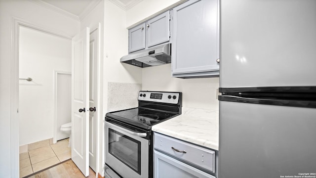 kitchen featuring appliances with stainless steel finishes, light hardwood / wood-style floors, crown molding, and gray cabinetry