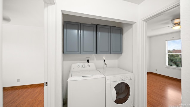 laundry area with cabinets, light wood-type flooring, and washing machine and clothes dryer