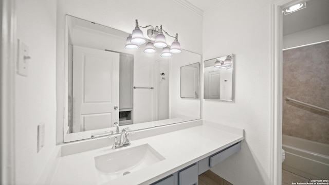 bathroom featuring a bathing tub, vanity, toilet, and crown molding