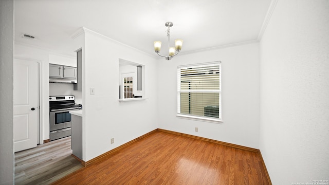 unfurnished dining area featuring a chandelier, wood-type flooring, and ornamental molding