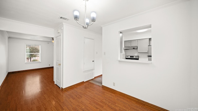 unfurnished dining area featuring hardwood / wood-style floors, crown molding, and an inviting chandelier