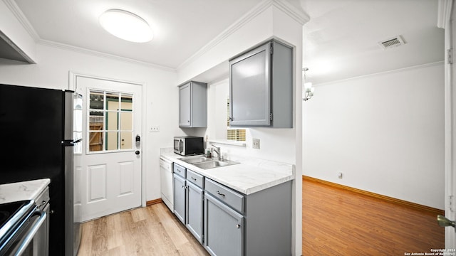 kitchen with gray cabinetry, crown molding, sink, light hardwood / wood-style floors, and stainless steel appliances