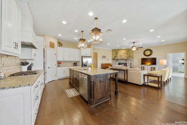 kitchen featuring dark hardwood / wood-style flooring, white cabinets, an island with sink, and appliances with stainless steel finishes