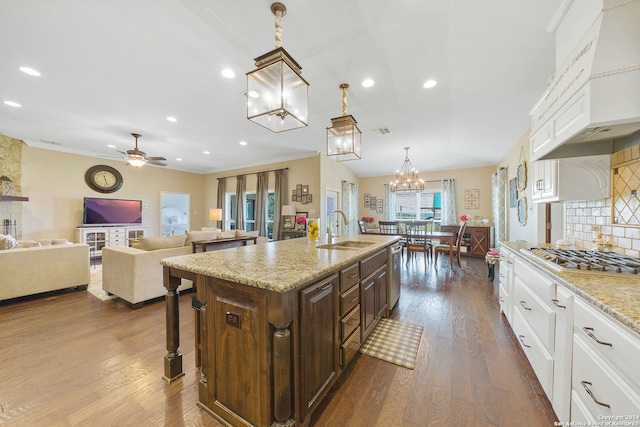 kitchen with a kitchen island with sink, sink, dark hardwood / wood-style floors, appliances with stainless steel finishes, and white cabinetry